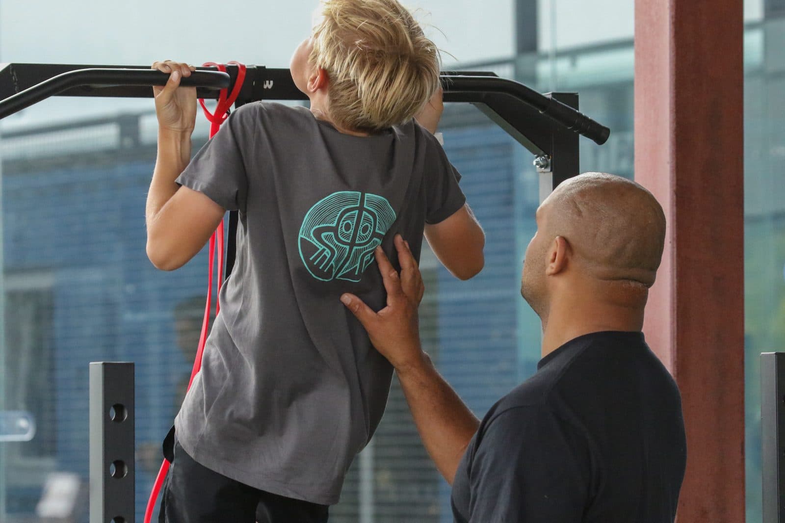 Morgan supporting a young athlete through an assisted pull-up